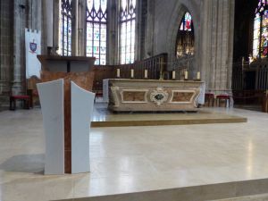 Le nouvel ambon en marbre rouge alicante et son parement de marbre blanc de carrare pur en harmonie avec les matériaux de l'autel